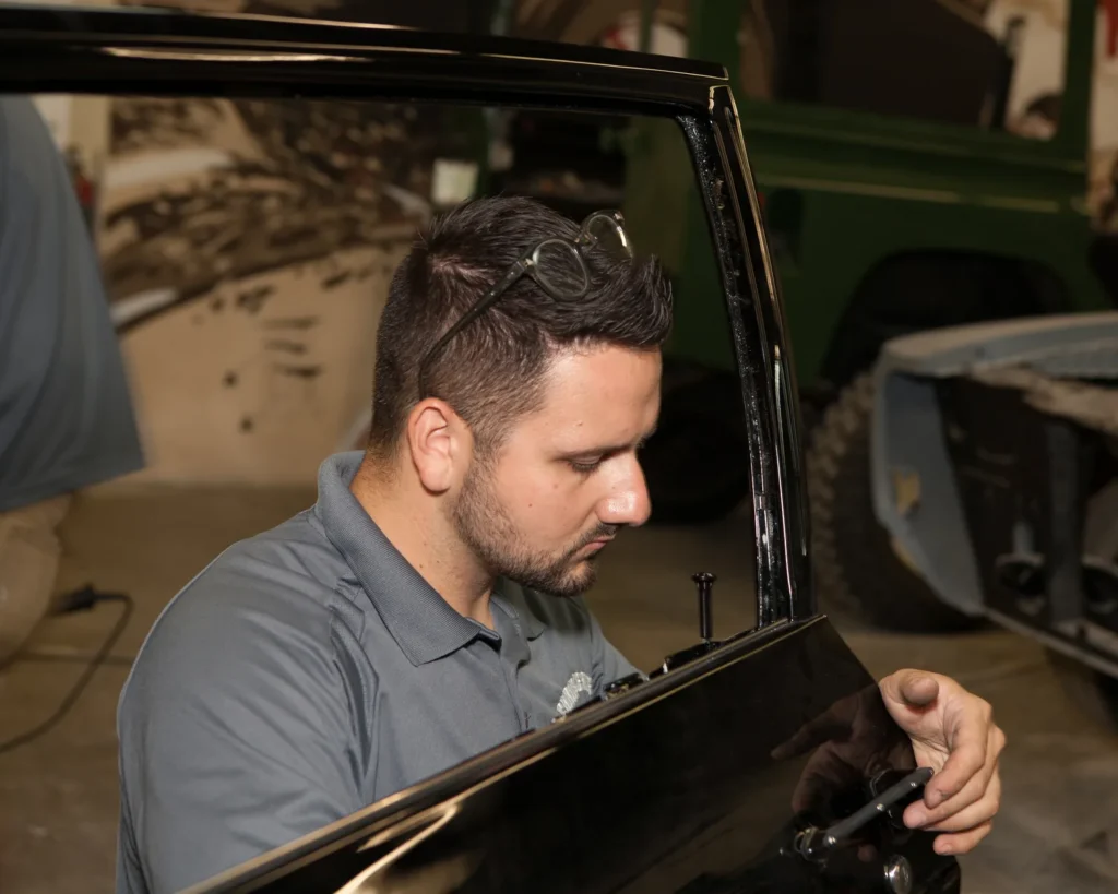 Chris Cerce inspecting a body panel inside the shop
