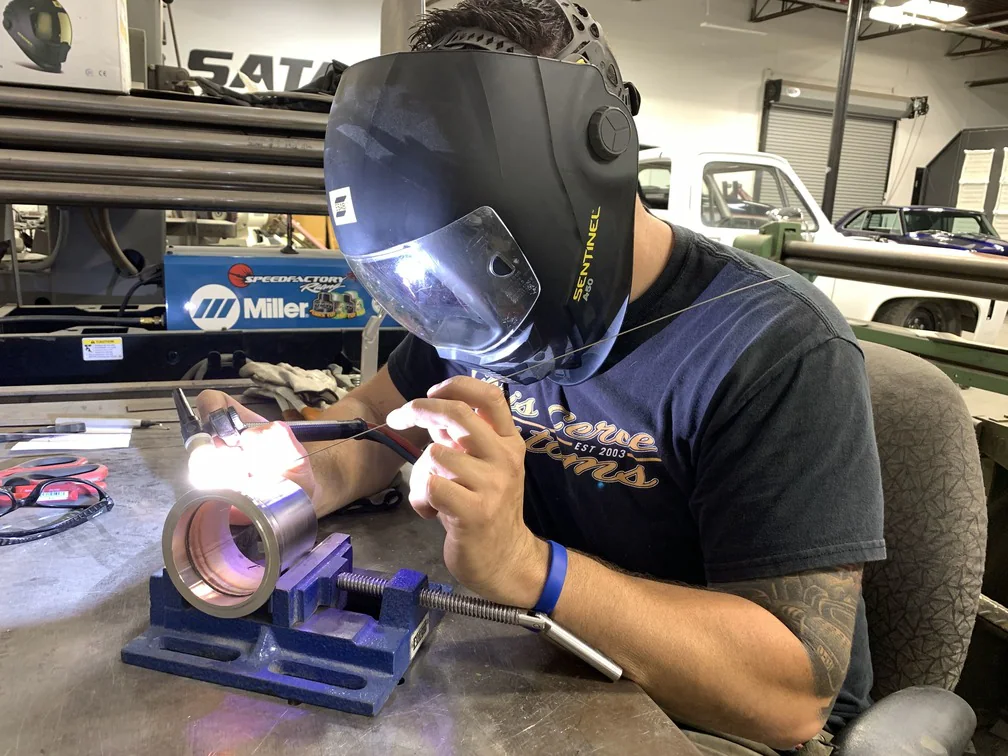 Fabricator TIG-welding a metal component inside the shop
