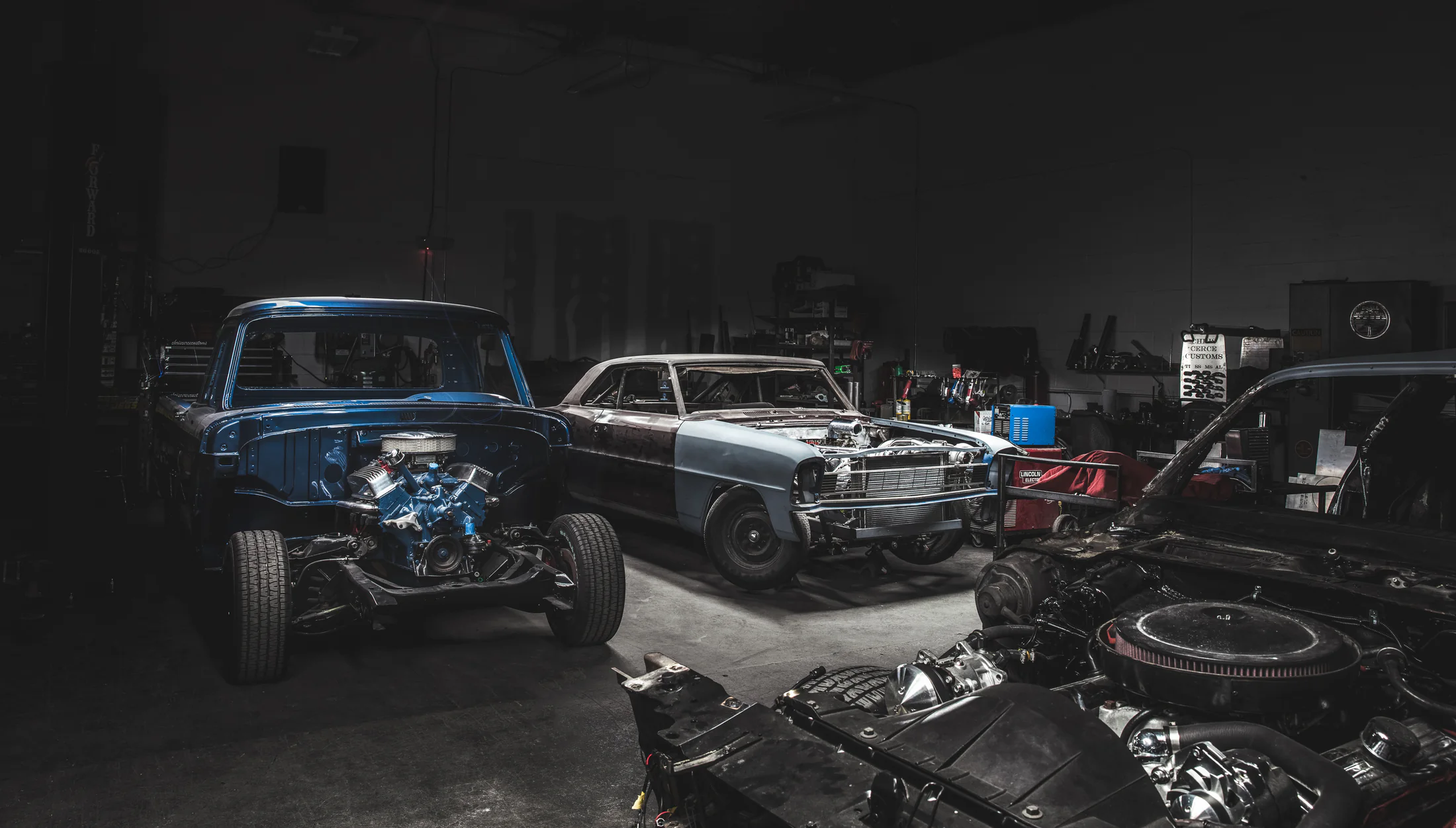 Multiple classic vehicle projects inside a Chris Cerce Customs workshop