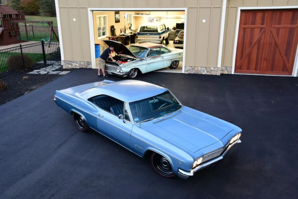 Light blue 1966 Chevrolet Impala SS outside the garage
